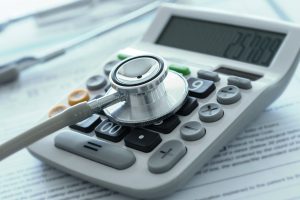 health care costs or medical insurance savings concept. stethoscope on calculator with medical billing.